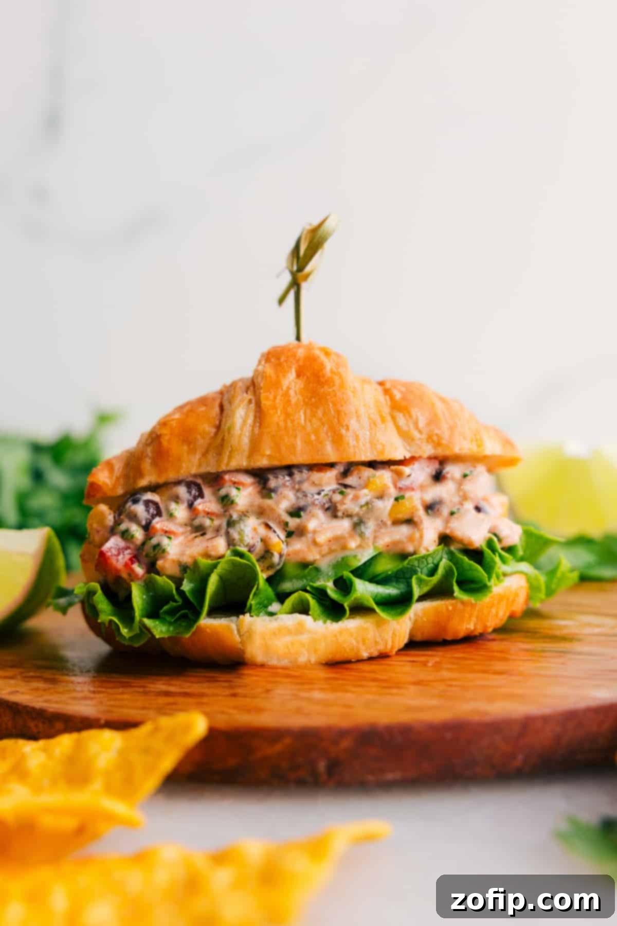 Southwest Chicken Salad on a croissant with lettuce, showcasing its vibrant ingredients.