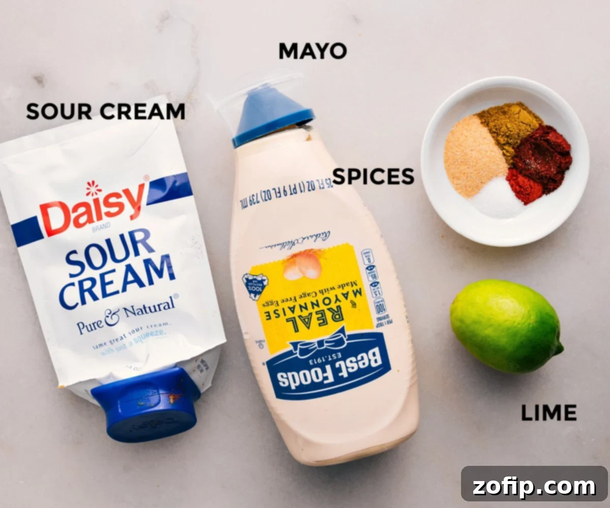 Dressing ingredients prepped for easy assembly in this Southwest Chicken Salad recipe: sour cream, mayo, a blend of chili powder, garlic powder, cumin, paprika, and fresh lime.
