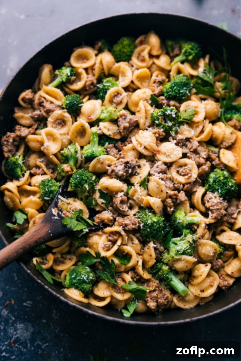 Italian Sausage and Broccoli Pasta 2 Overhead image of a vibrant plate of Orecchiette, Sausage, and Broccoli Pasta, garnished with fresh herbs and Parmesan cheese.