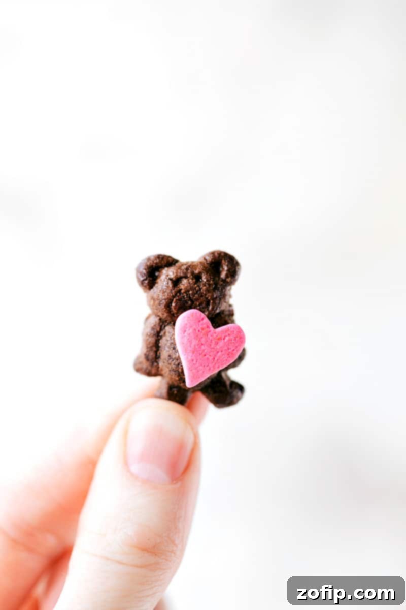 Mini Teddy Graham bear holding a heart sprinkle, a super cute and easy Valentine's Day snack idea.