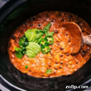 A top-down view of the irresistible Crockpot Chicken Enchilada Casserole, showcasing its rich, cheesy layers and vibrant toppings, perfect for a family meal.