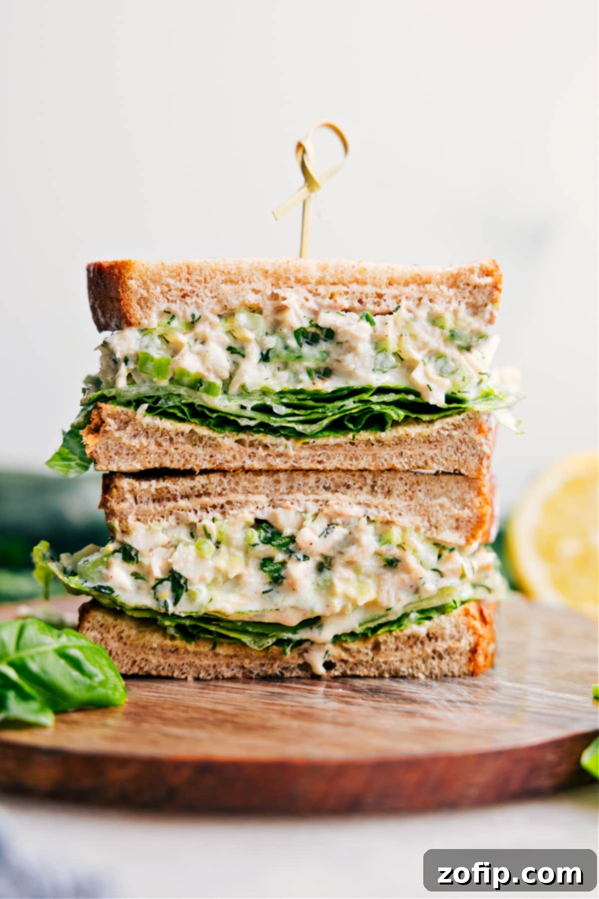 Lemon Basil Chicken Salad Sandwich Recipe Lemon-Basil Chicken Salad in bread makes a sandwich, with the sandwich cut in half and stacked on top of each other.
