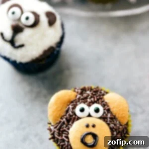 Close-up of a charming monkey cupcake, decorated with chocolate sprinkles, vanilla wafer ears and face, and candy eyes.