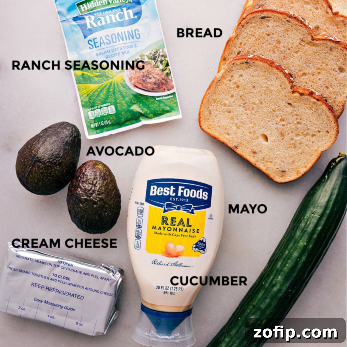 Ingredients In Avocado Sandwich Recipe All the fresh ingredients for the avocado sandwich, including sliced bread, ranch seasoning, various vegetables, mayonnaise, and cream cheese, prepped and ready for assembly.