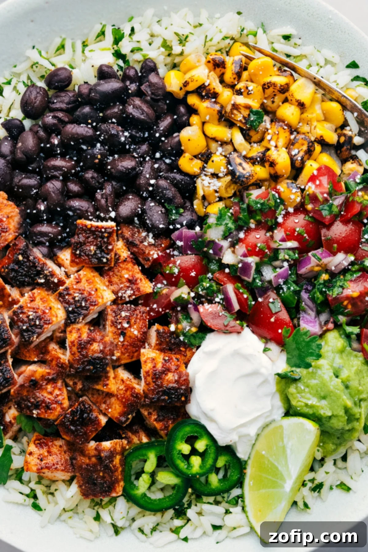 Fully assembled Chicken Burrito Bowls with a variety of colorful toppings.