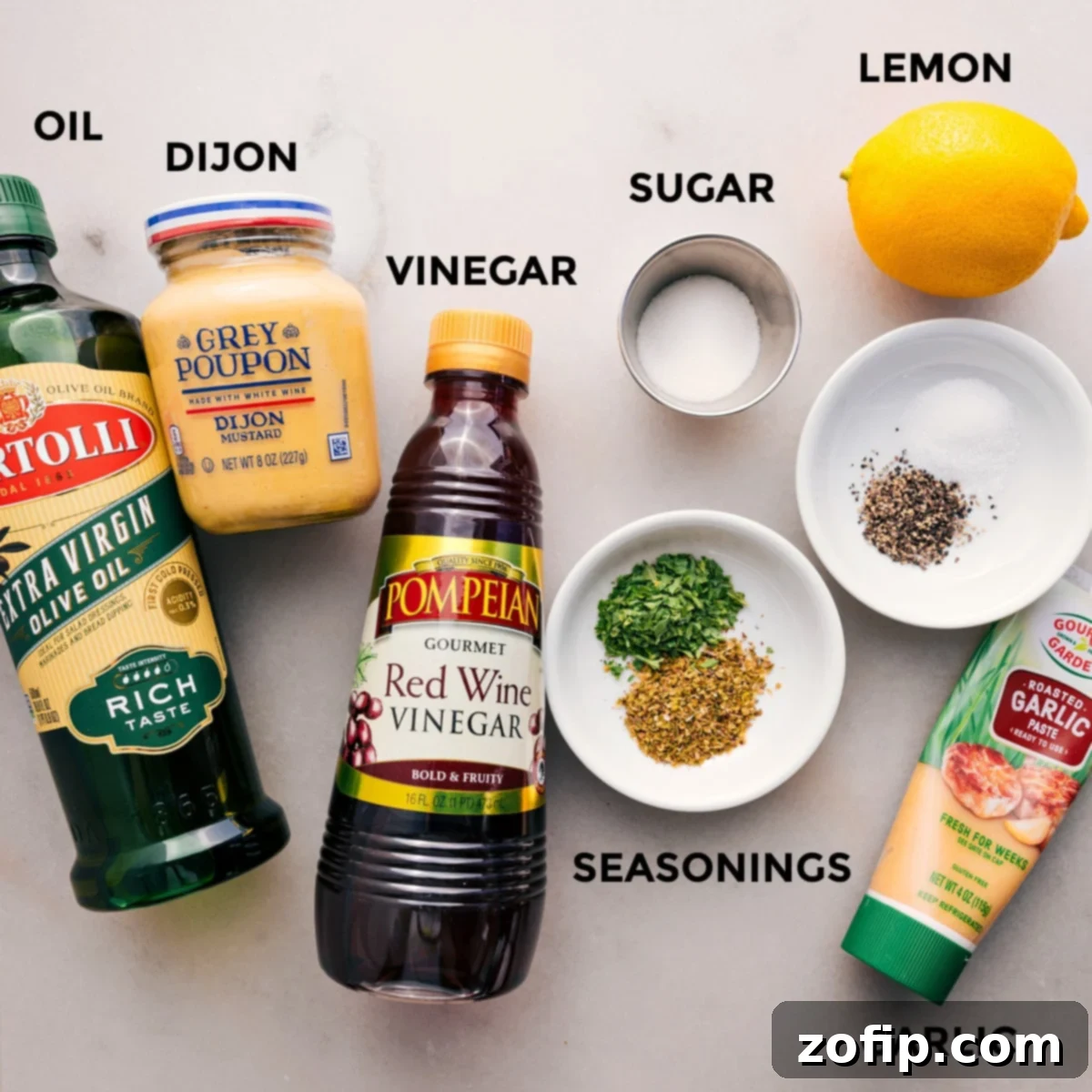 All the dressing ingredients for the Dense Bean Salad are meticulously prepped and arranged on a countertop, including olive oil, Dijon mustard, red wine vinegar, sugar, various seasonings, minced garlic, and fresh lemon slices, ready for blending.