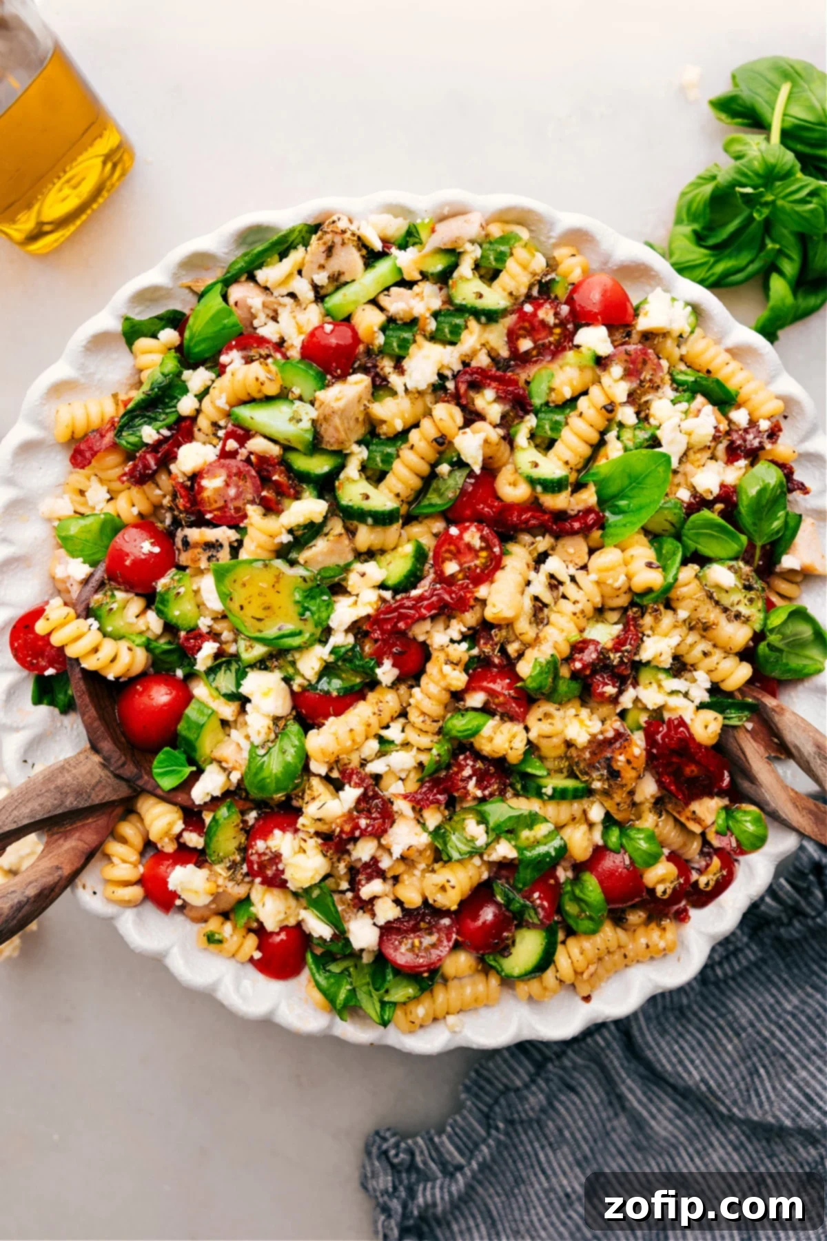 Irresistible Marry Me Chicken Pasta Salad Recipe A serving of Marry Me Chicken Pasta Salad in a white bowl, garnished with fresh basil, ready to be enjoyed.