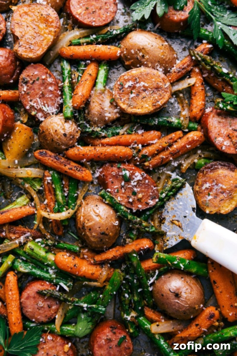 A sheet pan filled with a finished potatoes and sausage dinner, cooked to perfection and seasoned to enhance all the flavors, promising a delicious meal.