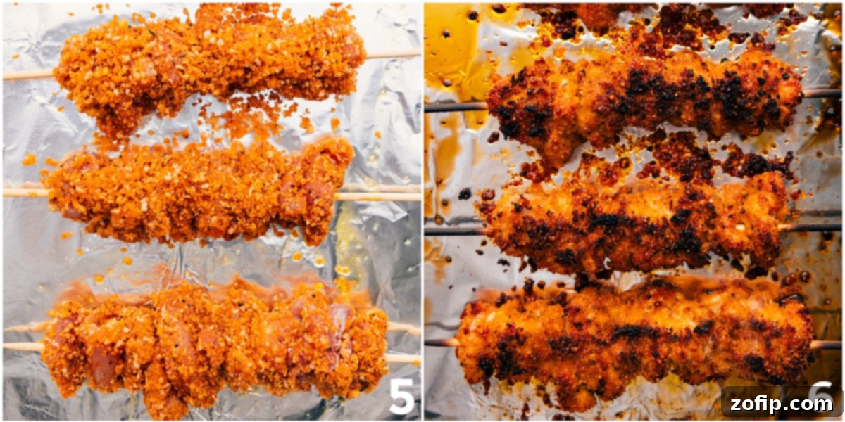 Crispy hot honey chicken threaded onto metal skewers, perfectly cooked and golden brown after broiling in the oven.