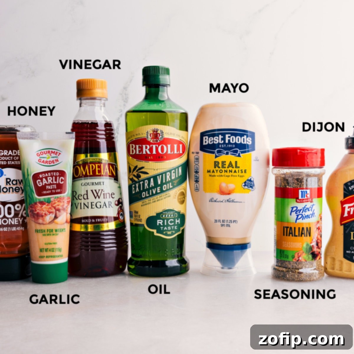 All the dressing ingredients for this Italian Grinder Pasta Salad are prepped for easy mixing—honey, garlic, vinegar, oil, mayo, seasoning, and Dijon.