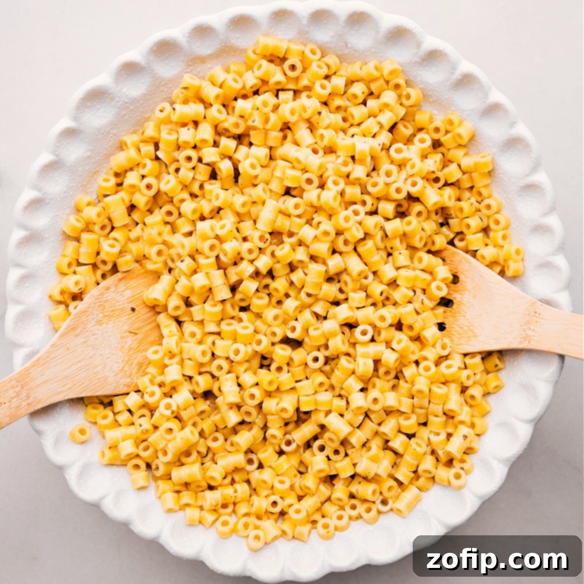 Cooked pasta sits in a bowl, ready to toss with the other ingredients for this Italian Grinder Pasta Salad.