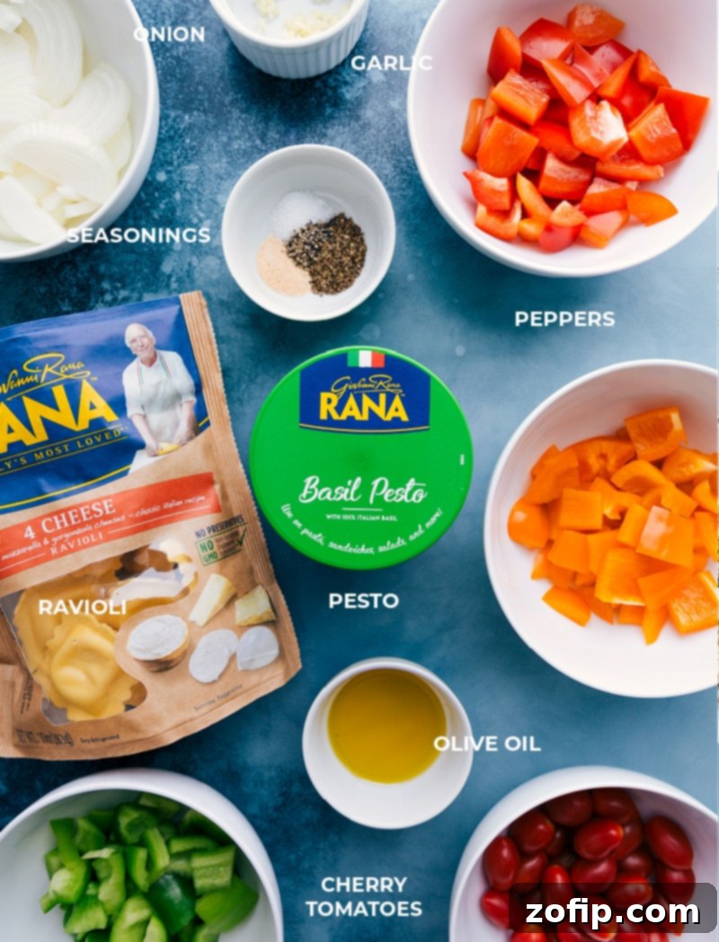 Collection of fresh ingredients for Pesto Ravioli including bell peppers, onion, cherry tomatoes, fresh ravioli, and basil pesto