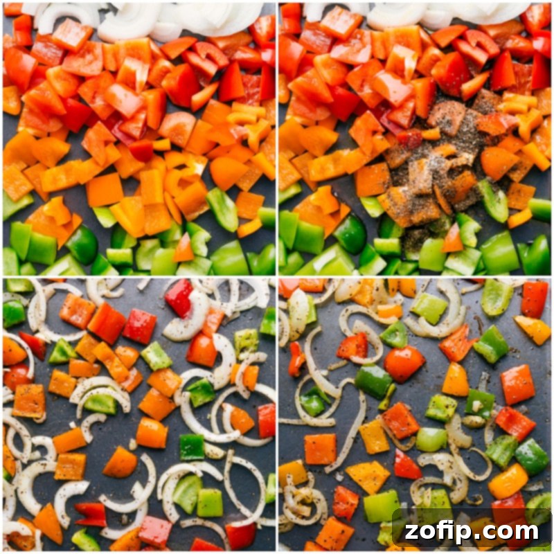 Bell peppers and onions being tossed with olive oil and seasonings on a large sheet pan before roasting