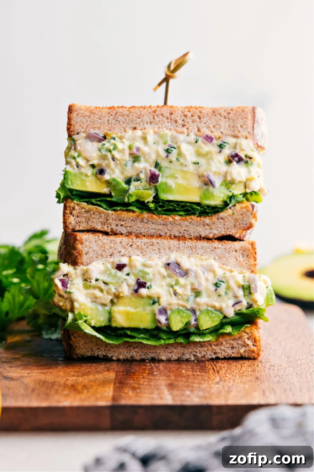 Delicious Chicken Avocado Sandwich, sliced in half and stacked to show off its creamy, fresh filling on toasted bread.