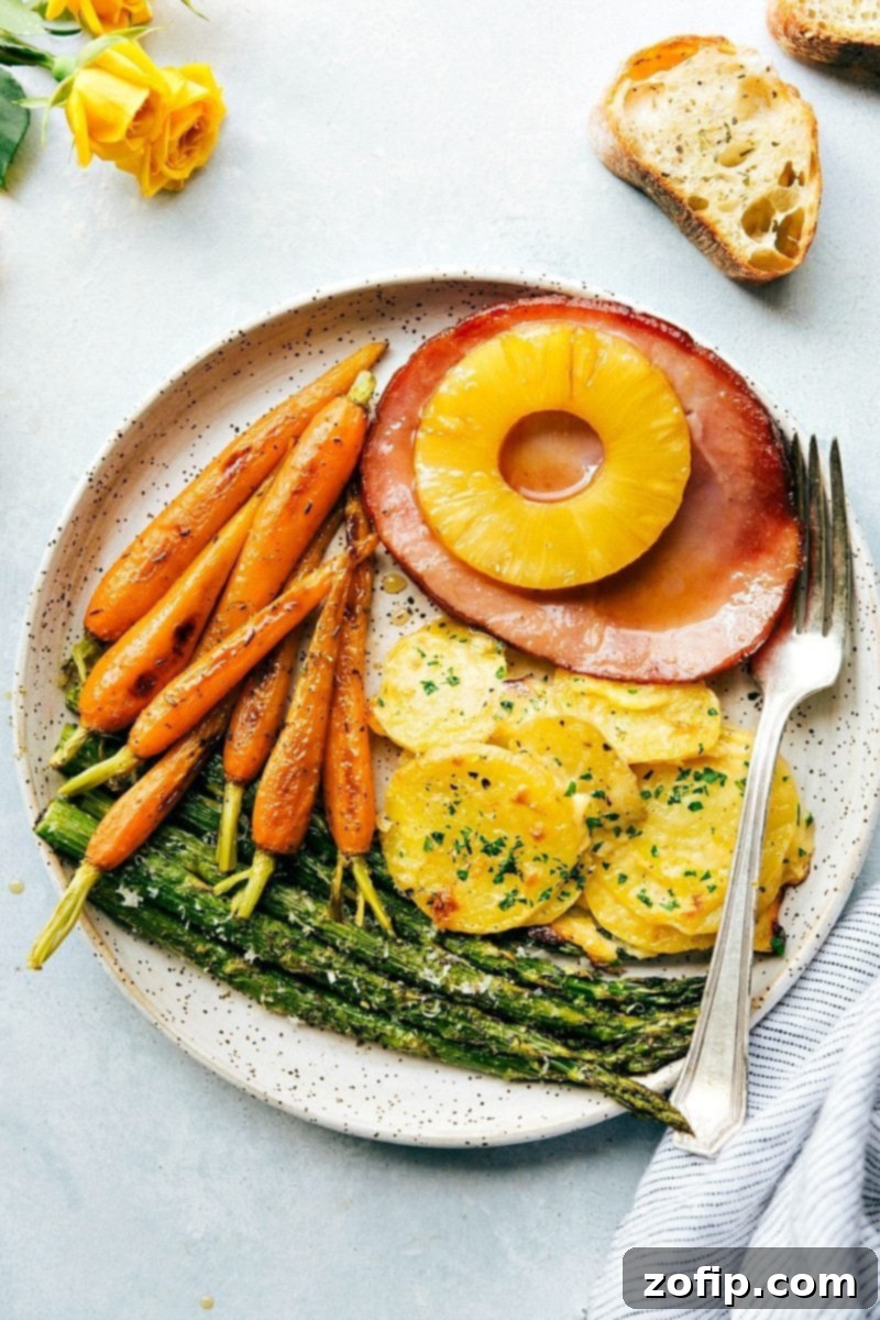 An entire Easter Dinner made in an hour (or less), baked in the oven together, and all on 2 sheet pans! A vibrant plateful of a complete Easter dinner, featuring succulent ham, perfectly roasted carrots, creamy au gratin potatoes, and tender asparagus.