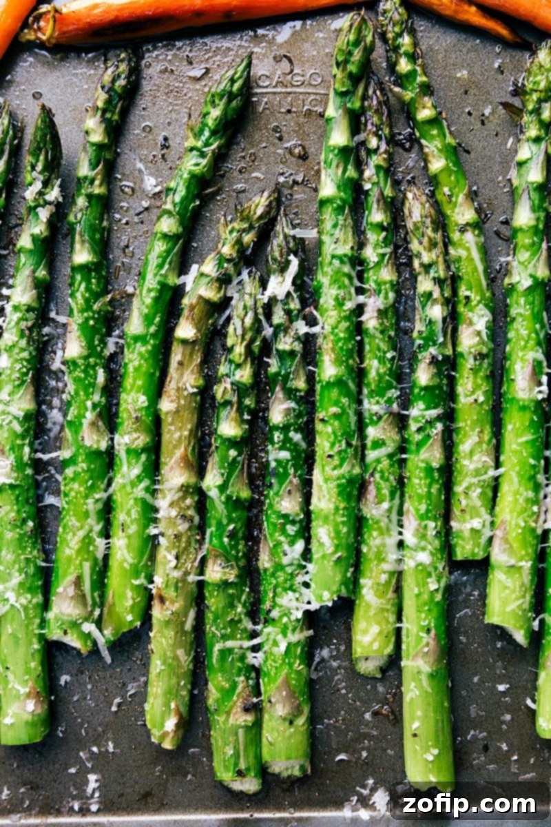 A close-up of the tender roasted asparagus, a simple yet elegant side for your Easter feast. Close-up image of perfectly roasted asparagus, glistening with olive oil and seasoned herbs, ready to be topped with Parmesan.