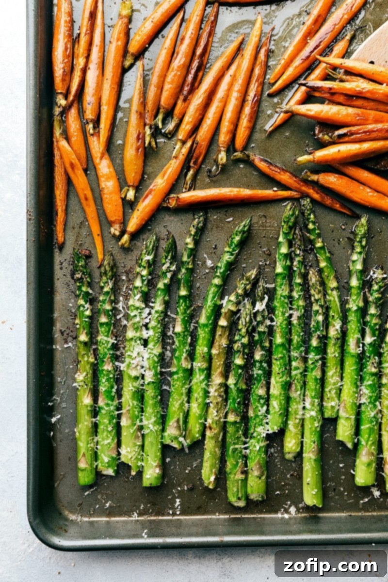 Carrots and asparagus, perfectly seasoned, share a sheet pan for maximum cooking efficiency and flavor. A sheet pan loaded with colorful honey-glazed carrots and vibrant green Parmesan asparagus, illustrating the ease of sheet pan cooking for Easter.