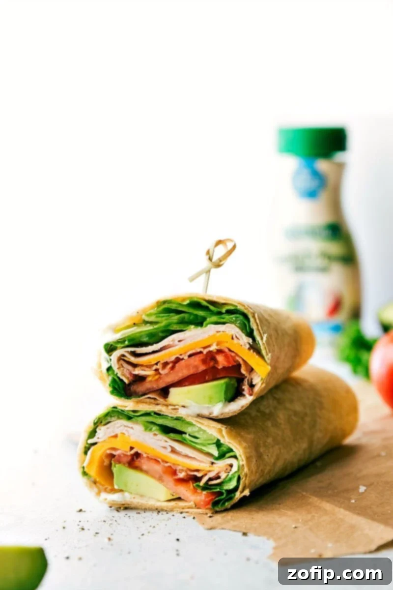 Enjoy these tasty and nutritious Turkey Avocado Wraps, loved by both kids and adults. Perfect for busy weeknights or quick lunches, they are packed with smoky deli turkey, sharp Cheddar, fresh lettuce, juicy tomatoes, and creamy avocado for a perfect balance of flavors and textures. Stacked Turkey Avocado Wraps ready to be served