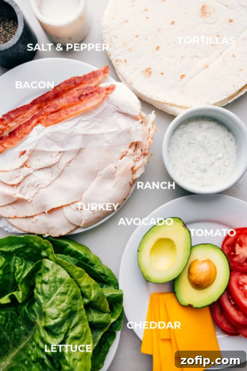 Whip up these tasty and nutritious Turkey Wraps with just a few simple ingredients. Both kids and adults will love them! Packed with smoky deli turkey, sharp Cheddar cheese, fresh lettuce, juicy tomatoes, and creamy avocado, these wraps offer a perfect balance of flavors and textures. Great for busy weeknights or a quick lunch. All fresh ingredients for Turkey Avocado Wraps laid out on a counter