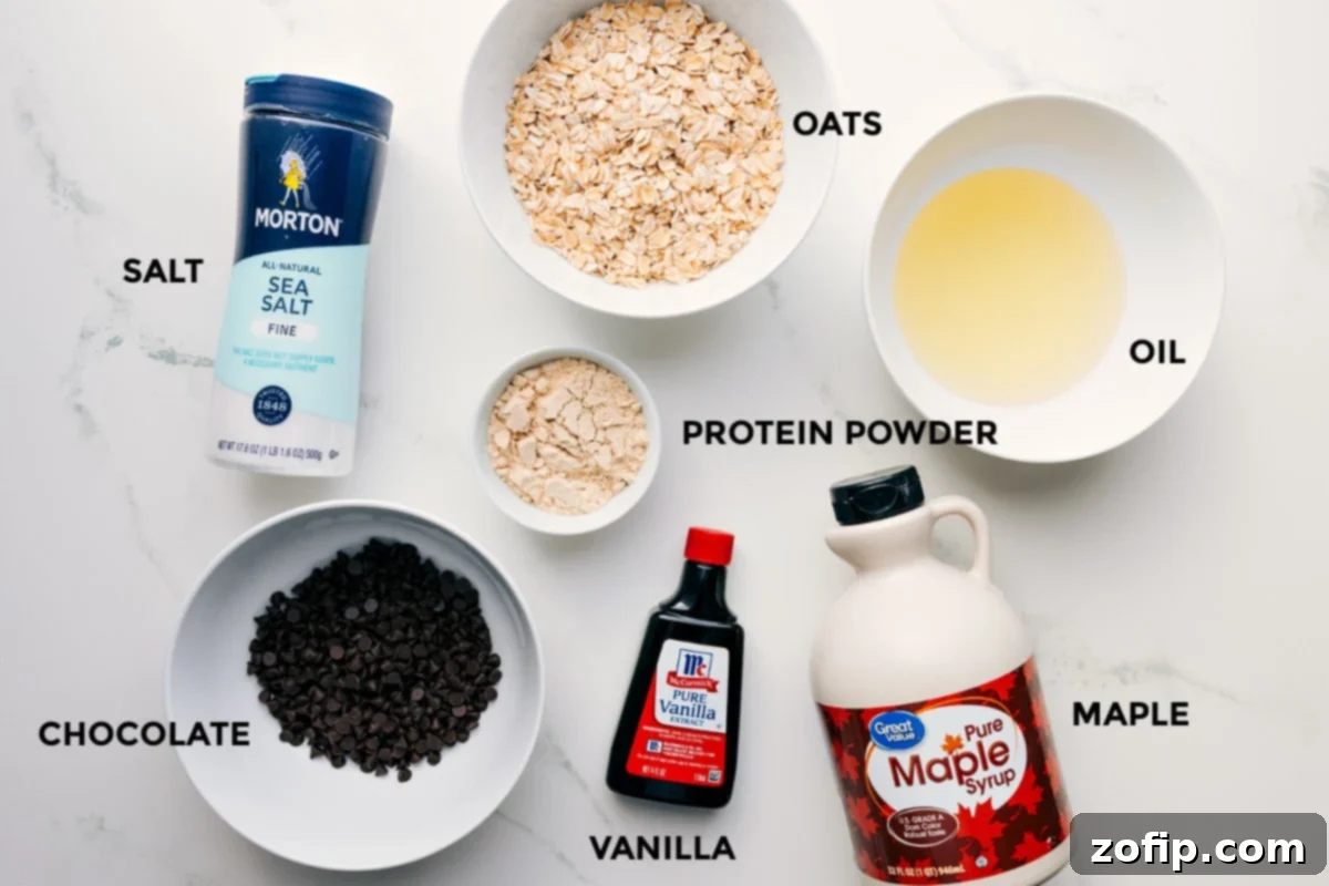 All the prepped ingredients for protein cookie dough: oats, oil, salt, protein powder, vanilla, maple syrup, and chocolate chips.