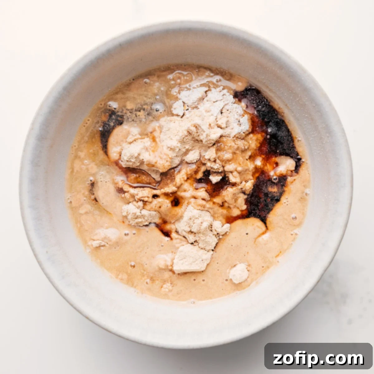 All the ingredients for protein cookie dough combined in a bowl to create the most delicious high-protein treat.