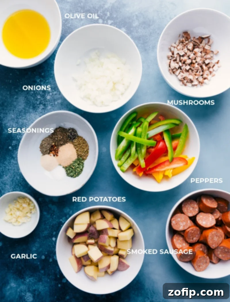 A selection of fresh ingredients including sausage, bell peppers, potatoes, and mushrooms for foil pack meal