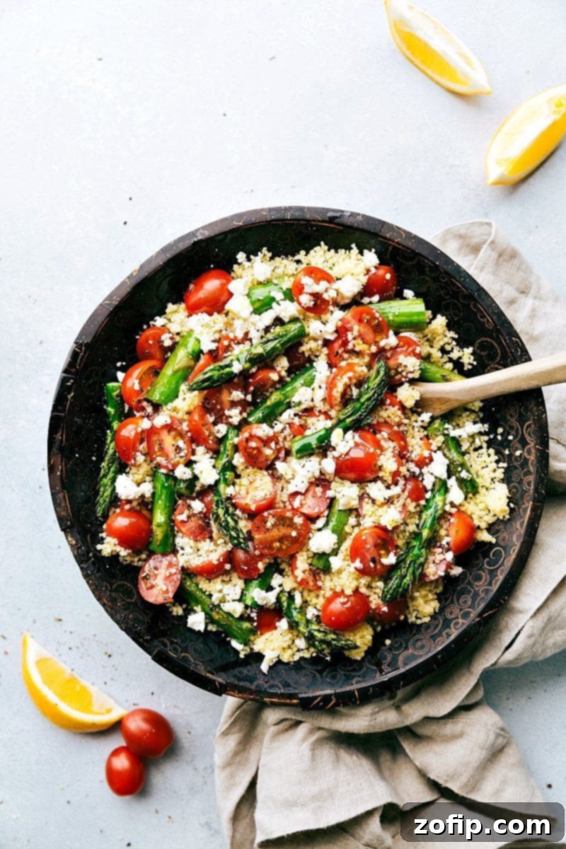 A vibrant Asparagus Salad featuring roasted asparagus, cherry tomatoes, couscous, and feta.