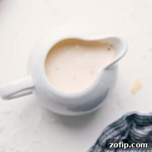 The Ultimate Homemade Caesar Dressing 3 A beautifully presented, creamy homemade Caesar Dressing in a glass jar, ready to be served over a fresh salad.