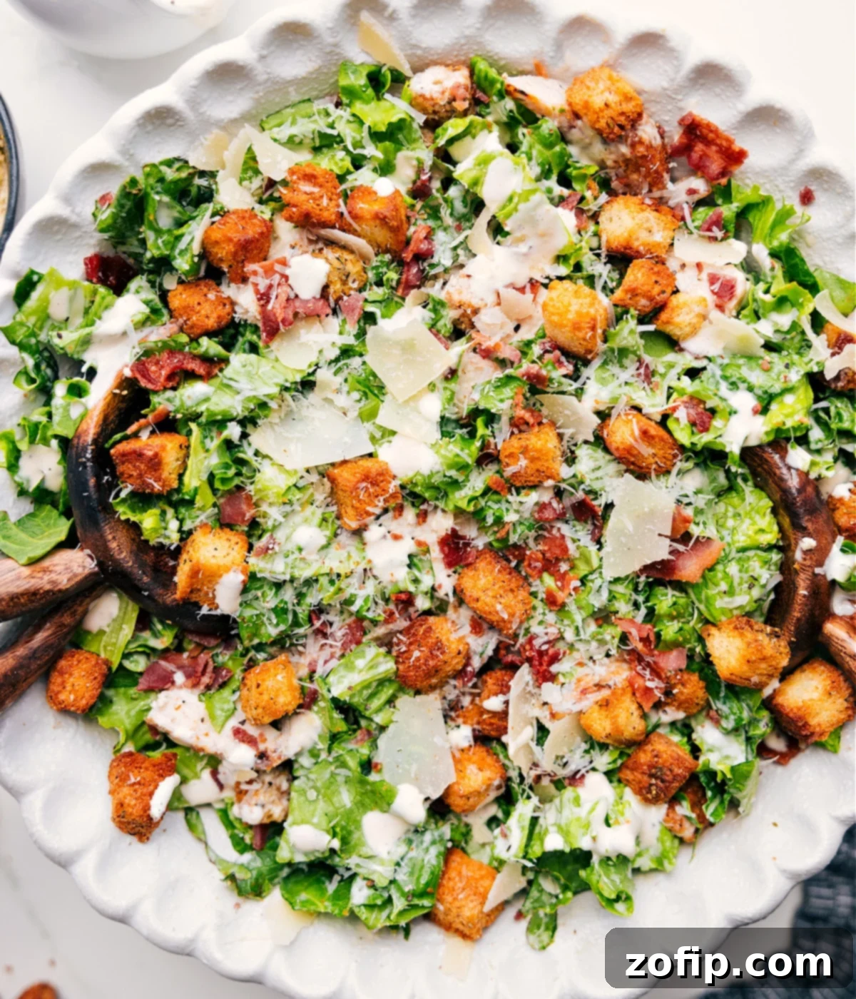 Classic Caesar Salad Dressed With Our Signature Caesar Dressing Recipe A vibrant Caesar salad, impeccably tossed with homemade dressing and generously topped with delectable croutons and fresh Parmesan, creating a satisfying and elegant dinner.