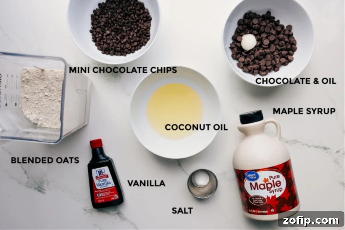 A vibrant flat lay of all the essential ingredients for making this simple Cookie Dough Bark recipe, including high-quality chocolate, coconut oil, pure maple syrup, vanilla extract, a pinch of salt, and rolled oats, all prepped and ready for seamless assembly.