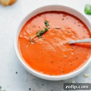 Homemade Roasted Tomato Basil Soup in a bowl with fresh thyme garnish.