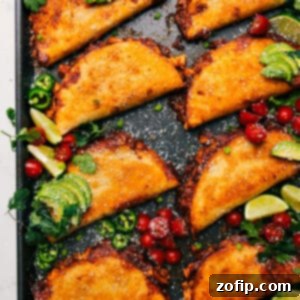 A close-up shot of the Crispy Baked Chicken Tacos, showing the golden-brown tortilla, melted cheese, and tender chicken filling, with a generous drizzle of the creamy chili-lime sauce.