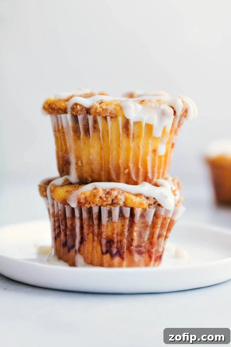 Photo of two Cinnamon Roll Cupcakes stacked on a plate, showing the swirl and glaze