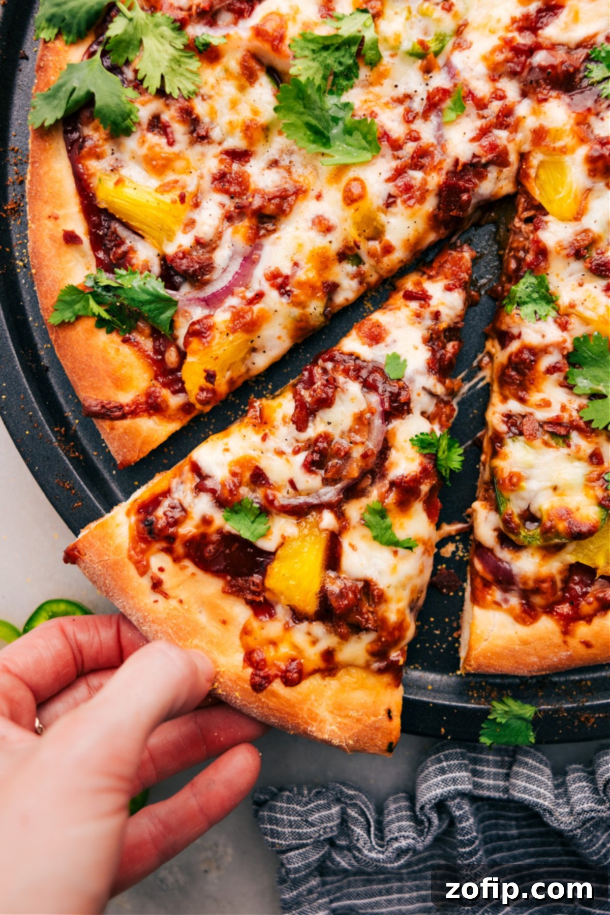 The Best Pizza Recipe With BBQ Chicken Slice A delicious single slice of BBQ Chicken Pizza lifted from the pan, showcasing the perfectly melted cheese, tender chicken, and other savory toppings, ready to be enjoyed.