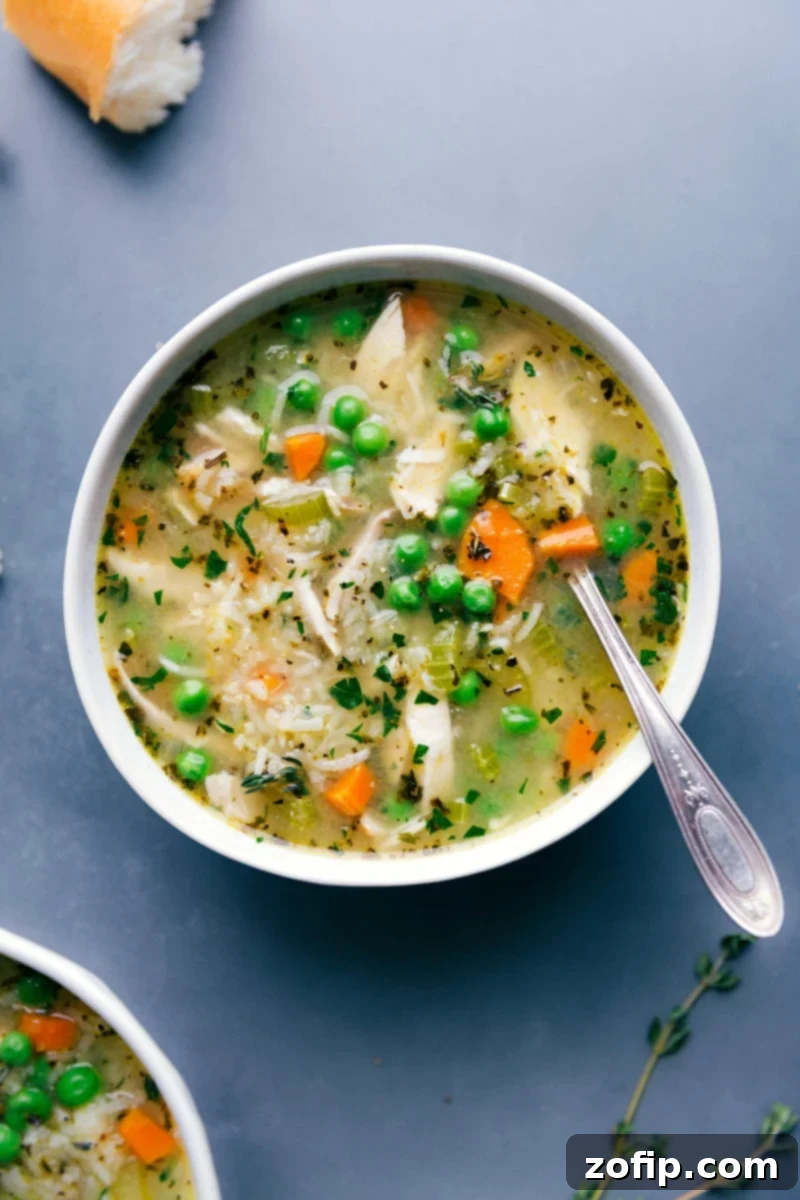 A steaming bowl of delicious chicken and rice soup, garnished with fresh herbs, ready to be enjoyed.
