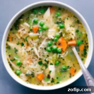 A beautifully presented bowl of chicken and rice soup, garnished with fresh herbs, signaling a delicious meal ready to be enjoyed.