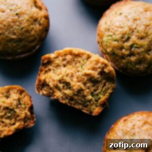 The finished healthy zucchini muffins, one split in half to reveal the moist interior.