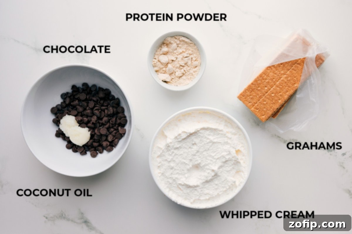 All ingredients laid out for Frozen Protein S’mores: graham crackers, thawed whipped topping, vanilla protein powder, chocolate chips, and coconut oil.