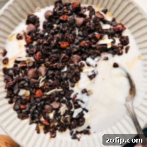 Decadent Chocolate Granola 3 Close-up of freshly baked chocolate granola with visible clusters and melted chocolate chips, ready to be enjoyed.