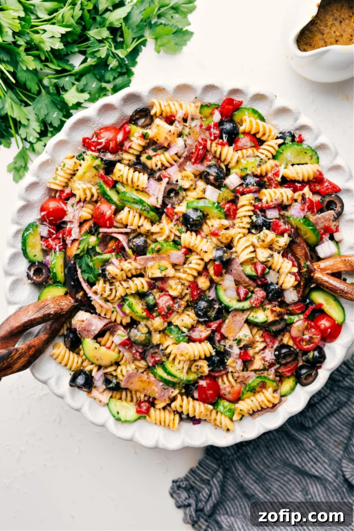 A stunning Italian Pasta Salad Recipe, overflowing in a rustic bowl, showcasing a medley of colorful fresh veggies, tender chicken, and a rich, flavorful dressing. It's garnished with fresh herbs, ready to be served and enjoyed on a warm day.