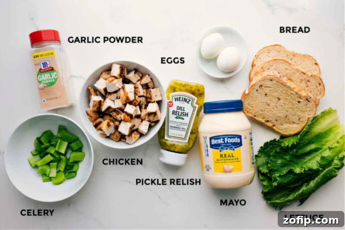 Essential Ingredients For Your Copycat Chick-Fil-A Chicken Salad Recipe All ingredients for Chick-Fil-A Chicken Salad Recipe prepped and ready, including chicken, garlic powder, celery, relish, eggs, bread, and lettuce.