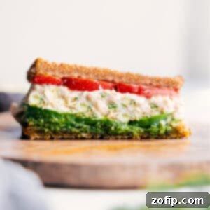 Avocado Tuna Medley 3 A freshly made Tunacado sandwich, cut in half, showcasing the layers of tuna, avocado, pesto, and tomato.