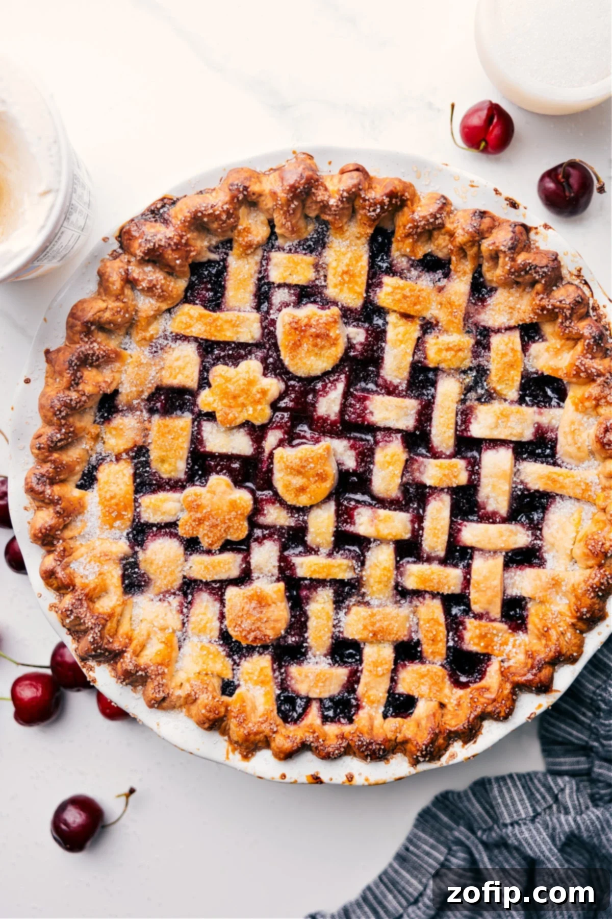 Golden-brown homemade cherry pie, fresh out of the oven, boasting a bubbly filling and perfectly crimped edges, ready to be sliced and served.