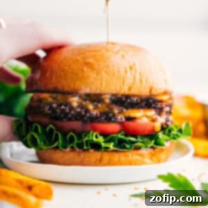 A mouth-watering close-up of a finished smash burger, showcasing its crispy patty, melted cheese, fresh toppings, and toasted bun.