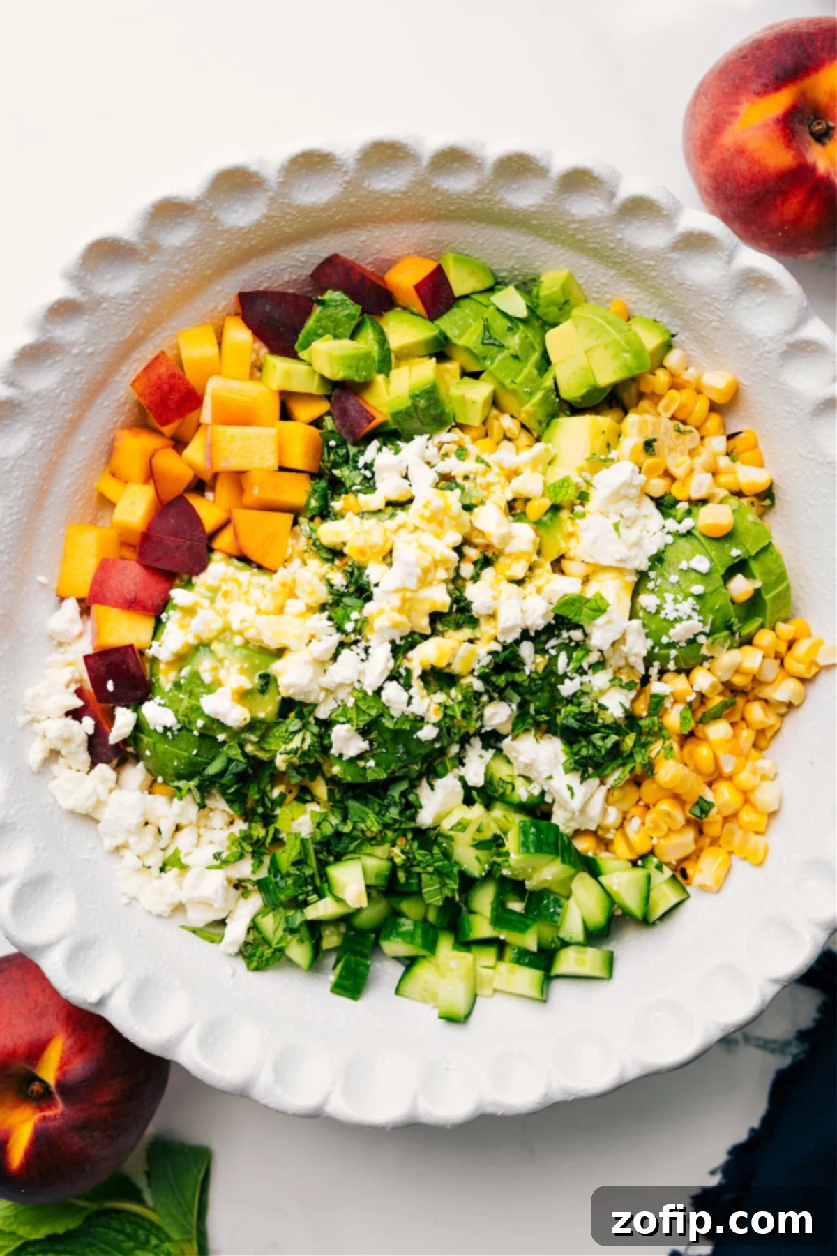 Peach Feta Salad Recipe Assembly A bowl of Peach Feta Salad, beautifully drizzled with citrus dressing, awaiting a gentle toss before being served.