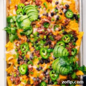 A close-up shot of delicious Pulled Pork Nachos with melted cheese and fresh toppings.