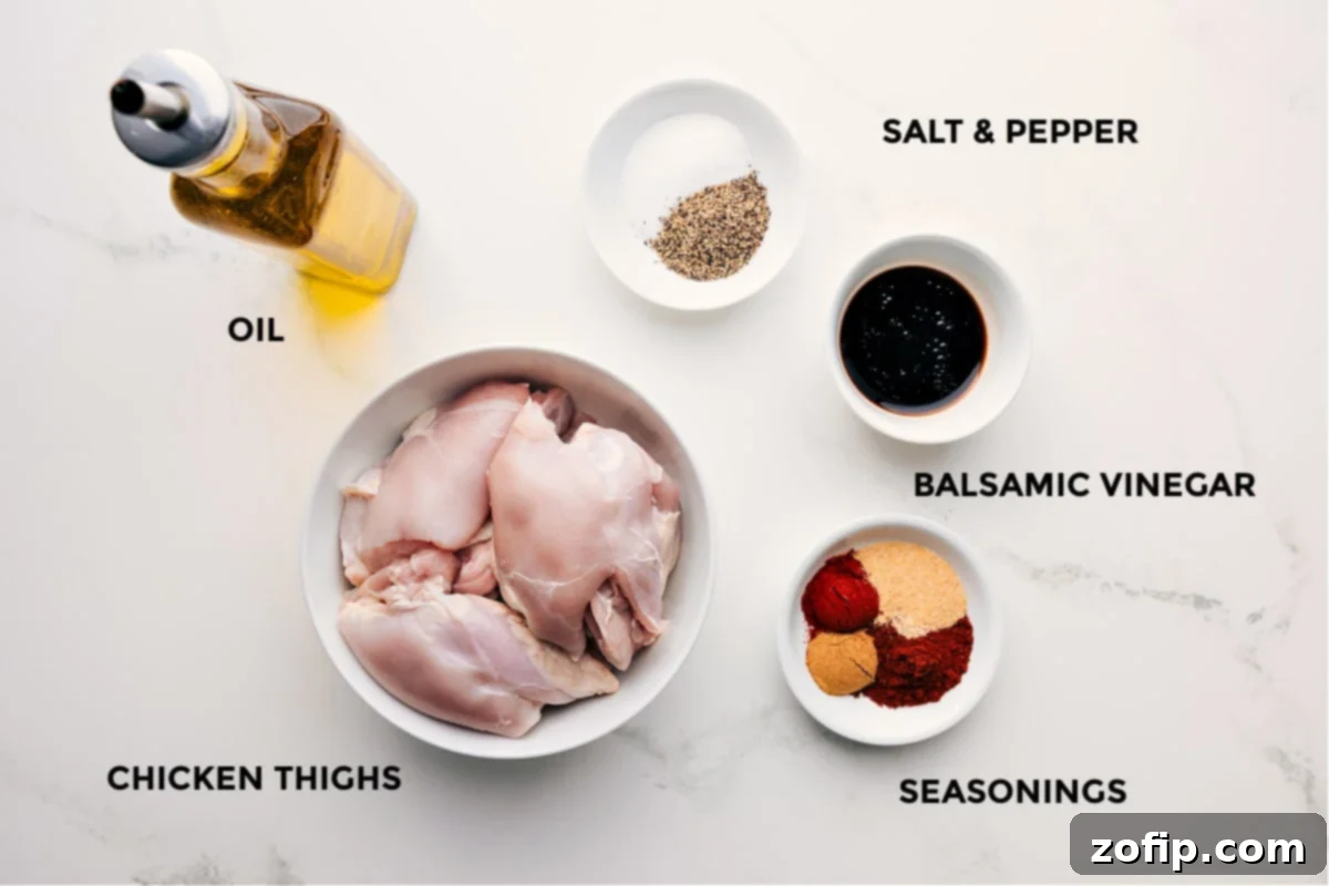 All the fresh ingredients laid out for making the baked chicken thighs recipe, including chicken, olive oil, balsamic vinegar, and a blend of spices.