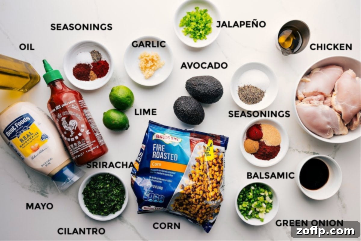 All the fresh ingredients for Street Corn Chicken Rice Bowl laid out including chicken, corn, avocado, lime, cilantro, spices, and sauce components.