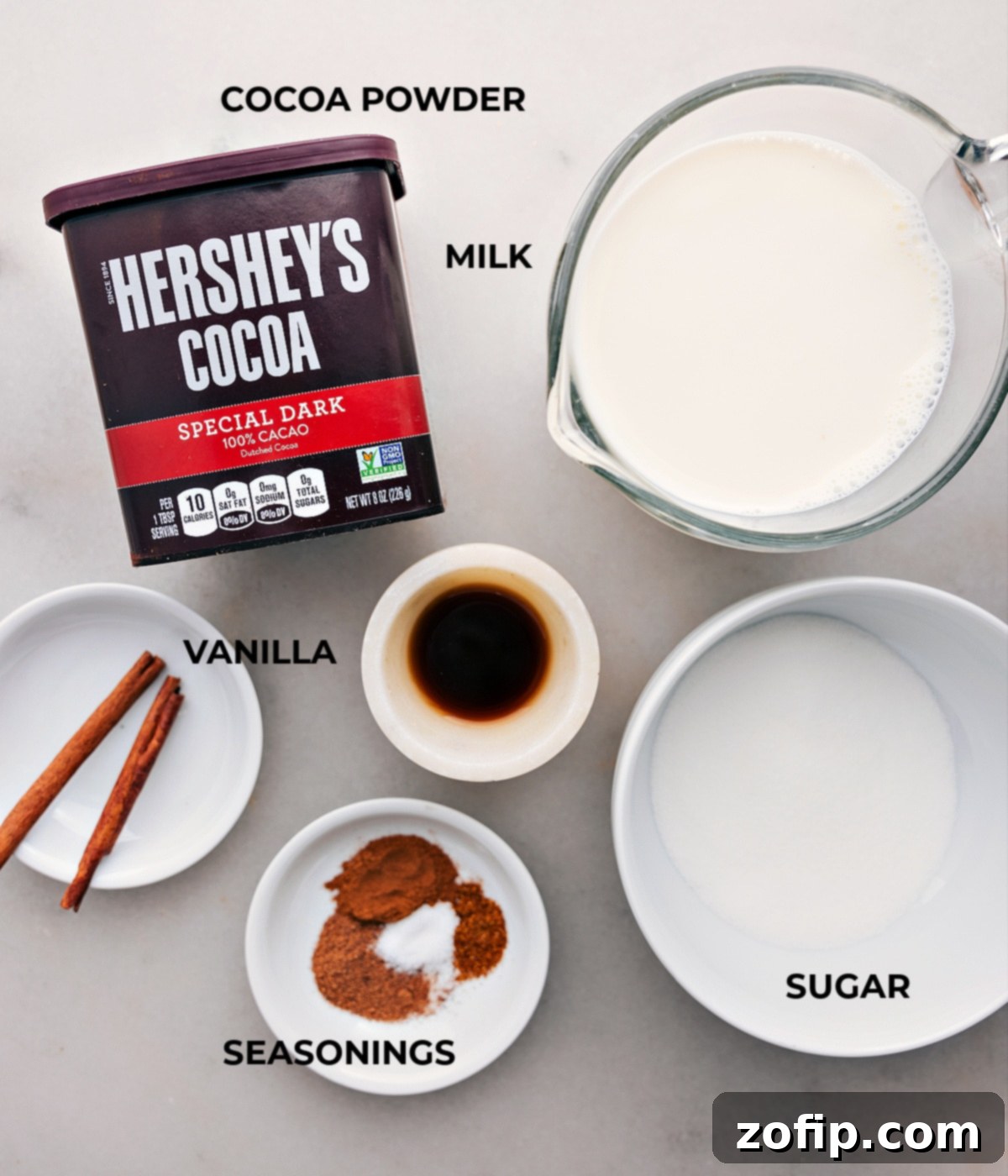 Essential ingredients for crafting luxurious Mexican Hot Chocolate Arrangement of ingredients including milk, rich cocoa powder, and additional elements for the Mexican Hot Chocolate recipe.