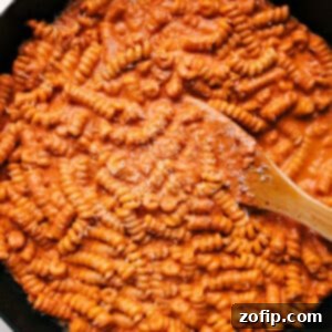 A close-up of the delicious creamy tomato pasta in a bowl, ready to be served, garnished with fresh basil.